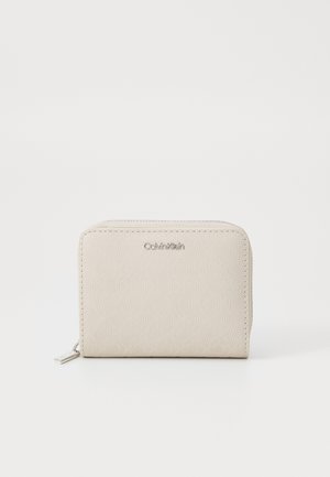 Beige wallet with geometric embossed pattern and silver logo. Features a zip closure and compact rectangular shape for easy portability.