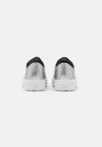 Sølv sneakers med metallisk finish, hvid gummisål, rund form og sort indvendigt. Har et minimalistisk design uden synligt hardware.