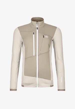 Beige and light cream softshell jacket with a high collar, zippered pockets, textured patterns, and contrasting panel design.