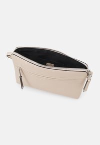 Beige leather bag with a textured surface, zip closure, interior pocket, and silver hardware. Opened view showing black lining.