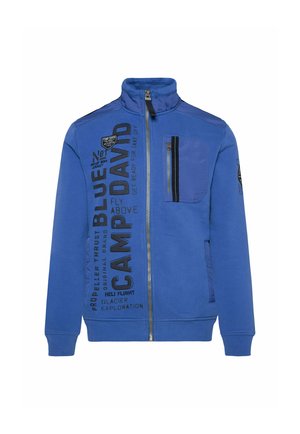 Blue zip-up jacket with high collar, featuring a chest pocket, black text graphics, and ribbed cuffs and hem. Smooth cotton blend material.