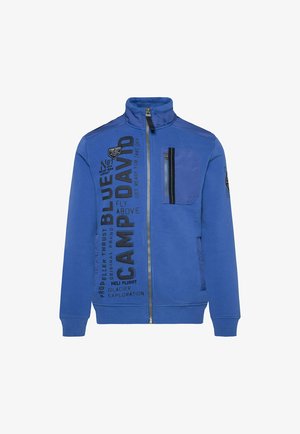 Blue zip-up jacket with high collar, featuring a chest pocket, black text graphics, and ribbed cuffs and hem. Smooth cotton blend material.