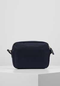 Laavakankainen laukkuseen, jossa on suorakulmainen muoto, vetoketjukiinnitys, kultaiset yksityiskohdat ja sivuolkaintop. Sileä pinta, minimalistinen muotoilu.