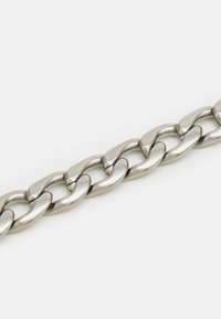 Metallinen ketjun kaulaketju, jossa on suuria, soikeita lenkkejä, sileä ja kiiltävä pinta, valmistettu ruostumattomasta teräksestä, joka näyttää lenkkien saumattoman yhteyden.
