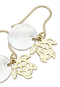 Boucles d'oreilles en métal doré ornées de disques ronds en nacre et de pendentifs tortues détaillés, alliant des finitions lisses et texturées.