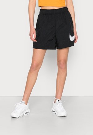 Svarta sportshorts med elastiskt midjeband, med en vit Nike-logotyp på sidan. Tillverkade av strukturerat syntetmaterial.