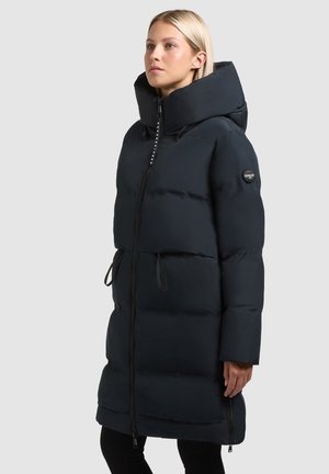 Giacca puffer blu navy con colletto alto, zip frontale e tasche laterali. Presenta una texture trapuntata e lacci in vita per una vestibilità regolabile.