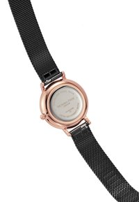 Reloj de pulsera redondo con correa de malla negra. La caja es de tono dorado con un fondo de acero inoxidable. La esfera presenta el grabado de la marca.