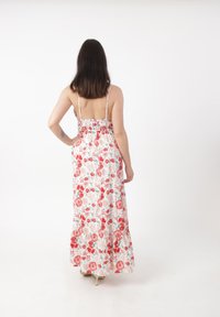 Blumen-Maxi-Kleid mit gerafftem Rücken, Spaghetti-Trägern und einem Rüschensaum. Mit roten und pinken Rosen auf weißem Hintergrund. Glatte Stoff текстur.