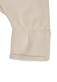 Beige fabric with a textured surface and a soft fleece lining at the cuff. The hem is finished with visible stitching.