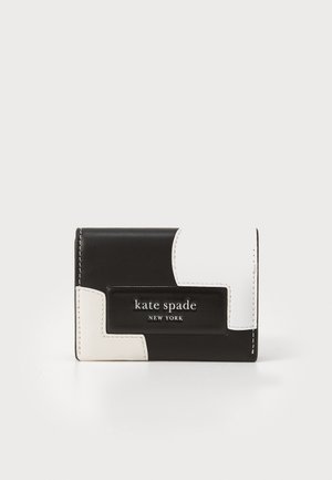 Carteira de couro preto e branco com design geométrico, apresentando uma placa de logotipo em metal. Superfície texturizada, costura em contraste, forma retangular compacta.