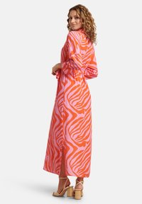 Abito maxi con un motivo a zebra in rosa e arancione, realizzato in tessuto leggero, con maniche lunghe e vita annodata per una silhouette aderente.