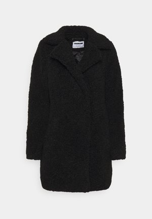 Cappotto teddy nero testurizzato con colletto a risvolto, maniche lunghe e vestibilità comoda, appeso su uno sfondo bianco semplice.