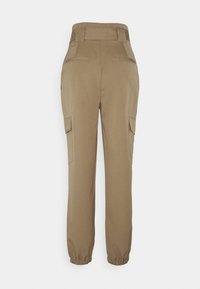 Khaaki spodnie cargo z wysokim stanem, elastycznymi mankietami, dwoma bocznymi kieszeniami i gładką fakturą. Zaprojektowane w tapered fit.