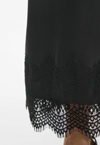 Črna obleka s teksturiranim satenskim zaključkom in zapletenim čipkastim robom s cvetličnimi vzorci, valovitimi robovi in rahlimi cofki.