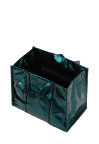 Türkiz fémes tote táska, fényes felülettel, két fogantyúval és belső cipzáras zsebbels. Nyitott kialakítás, lágy élekkel és zár nélkül.