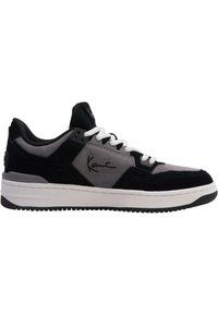 Svart og grå sneakers med semsket skinn og mesh-materialer, hvite lisser, svart gummisåle, signaturdetaljer på siden, og polstret krave.