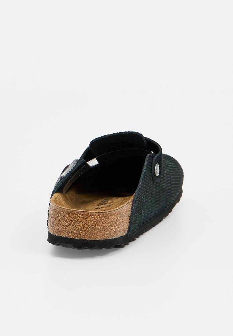 Schwarzer Cordura-Slipper mit Korksohle, der eine glatte Oberfläche und einen verstellbaren Riemen mit metallischen Akzenten aufweist.