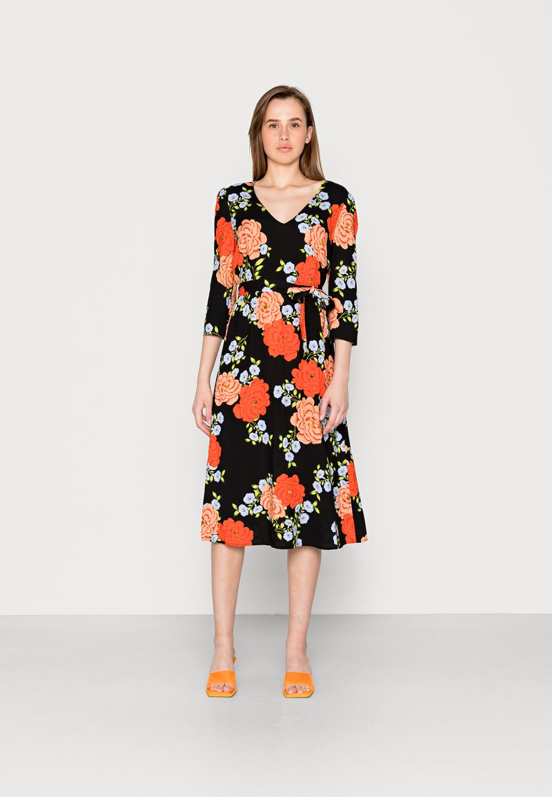 Vestido preto com estampa floral, apresentando grandes rosas laranja e detalhes azuis. Decote em V, mangas três quartos e um cinto atado na cintura.