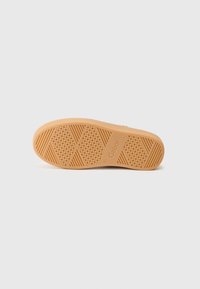 Rubber sole in tan color with a textured surface featuring hexagonal and diamond patterns. Gabor branding embossed on the side.