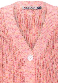 Strickjacke in Pink mit unterschiedlicher Textur. Sie hat einen tiefen V-Ausschnitt, einen einzigen Knopfverschluss und ein mehrfarbiges Muster in verschiedenen Rosa- und Gelbtönen.
