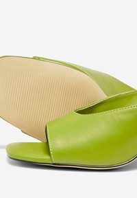 Zelené kožené skluzové boty s otevřenou špičkou, které mají hladký povrch, zaoblený tvar a béžovou gumovou podrážku s vroubkovaným designem.