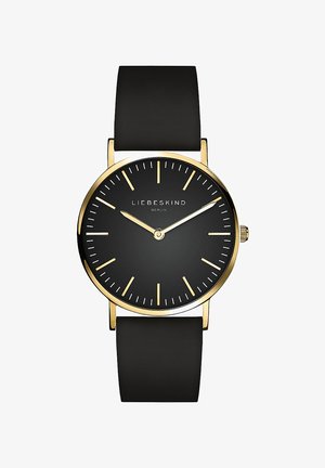 Sort ur med en rund urskive, guldkantede detaljer, slanke visere og et glat gummirem. Har minimalistisk design og klare timemarkører.