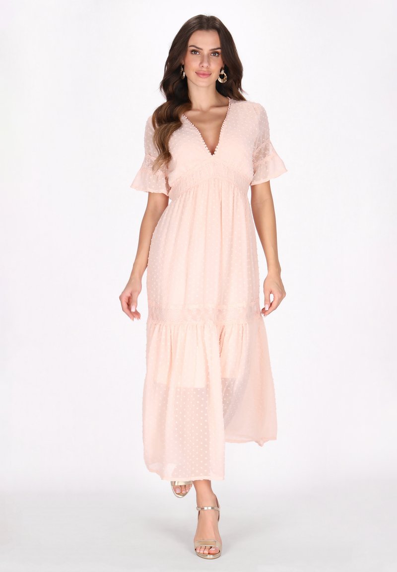 Helles rosa Maxikleid mit Polka-Dots, tiefem V-Ausschnitt, fließenden Ärmeln und gestuftem Rock. Mit Spitzenakzenten und einer schwingenden Silhouette.