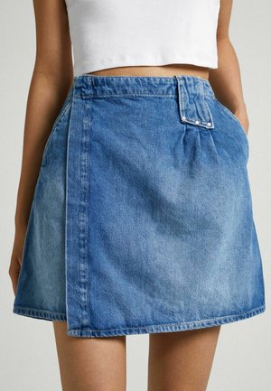 Jupe en denim mini en bleu clair avec un détail de rabat à l'avant, des poches latérales et des accents de couture. Présente une coupe décontractée et une texture douce.