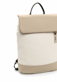 Beige und cremfarbene Rucksack mit glatter Oberfläche, Klappenverschluss, Handgriff an der Oberseite und verstellbaren schwarzen Trägern, mit klaren Linien und minimalistischer Gestaltung.