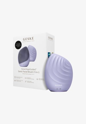 Brosse faciale sonique Lavender GESKE 5-en-1 avec texture ondulée, présentée à côté de son emballage blanc mettant en avant des caractéristiques comme la pulsation intelligente et un nettoyage en profondeur.