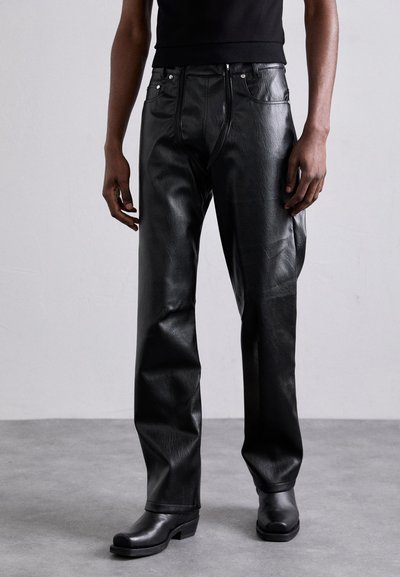 Pantaloni din piele neagră cu o textură netedă, design cu picătură dreaptă și fermoar frontal. Prezintă accente de hardware argintiu și o potrivire slim în talie.
