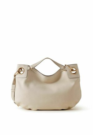 Sac à main en cuir beige de forme arrondie, garniture métallique circulaire dorée aux coins supérieurs et petite poignée sur le dessus.