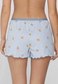 Blauwe gestreepte shorts met een gekartelde zoom, voorzien van een patroon van kleine teddyberen in verschillende kleuren. Zachte, lichte stof.