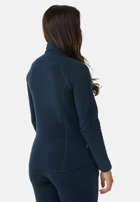 Marineblauwe fleece pullover met een hoge kraag, voorzien van stikseldetails en een aangesloten pasvorm. Zachte textuur en mouwlengte tot halverwege de arm.