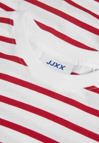 T-shirt de mangas curtas em branco com riscas horizontais vermelhas. Apresenta um decote redondo canelado e um rótulo com "JJXX" em azul.