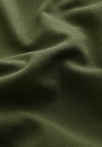 Alyvuogių žalia medžiaga su minkšta, tekstūruota paviršiaus struktūra, demonstruojanti raukšles ir klostes, tinkama drabužiams ar apmušalams.