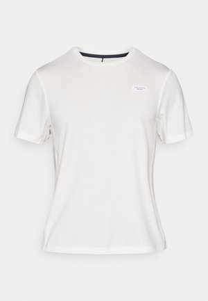 Balta īsām piedurknēm T-krekls, izgatavots no gludas auduma. Tam ir apaļa kakla izgriezums un mazs logo uzlīme frontē. Šaurs piegriezums.