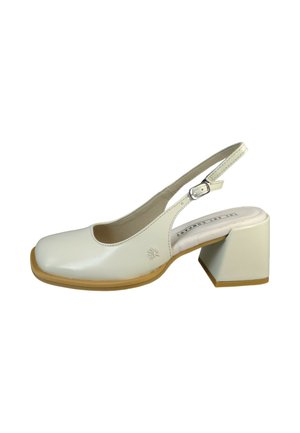 Crèmekleurige slingback schoen met vierkante neus, blokhak, verstelbare gespsluiting en bruine zool, van opzij getoond op een witte achtergrond.