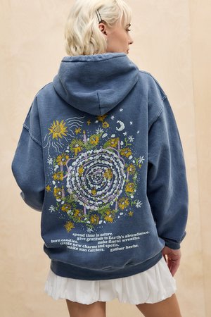 Blue fleece hoodie featuring a spiral floral design with sun, moon, and stars. Text on the lower back includes various nature-themed phrases.