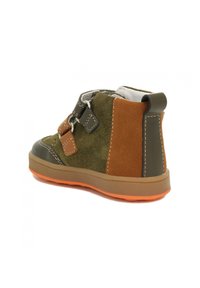 Kinderschuhe aus grünem und braunem Wildleder mit einer Gummisohle in Orange und zwei dekorativen Riemen an der Seite.