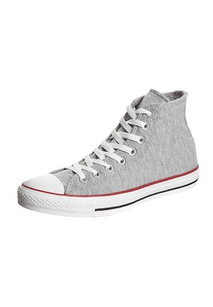 Grijze hoge canvas sneaker met witte rubberen neuskap, witte veters en witte zool met rode en zwarte strepen.