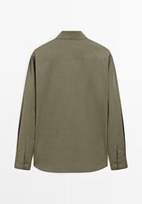 Chemise à manches longues vert olive avec poignets boutonnés et col classique, vue de dos sur fond blanc.