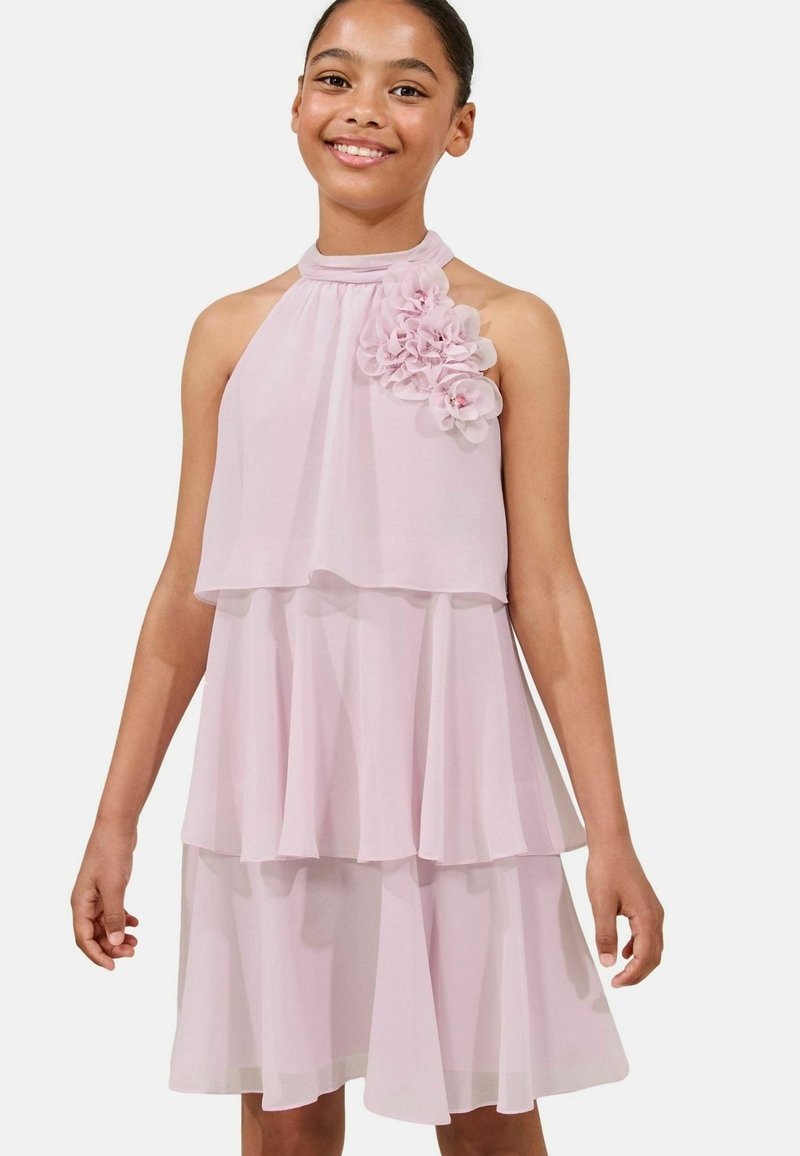 Rochie halter roz deschis cu un design stratificat, având un accent floral pe umăr. Fabricată dintr-un material moale, transparent, cu o textură fluidă.