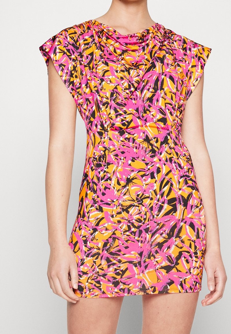 Robe ajustée sans manches avec un motif floral abstrait lumineux en rose, orange, noir et blanc sur une personne à la peau claire.