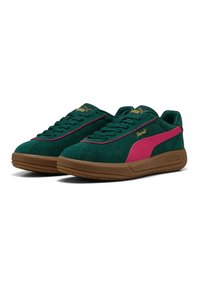 Grüne Wildledersneaker mit pinken Akzenten, runder Zehenpartie, strukturiertem Obermaterial und goldenem Logo. Braune Gummisohle mit dezentem Profil.