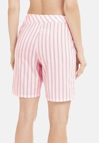 Roze gestreepte shorts met verticale lijnen in zwart en wit, gemaakt van een zachte stof en voorzien van een elastische tailleband voor extra comfort.