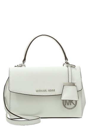 Biała torebka Michael Kors z uchwytem u góry, regulowanym paskiem na ramię, przednią klapą oraz metalową zawieszką z logo wiszącą z boku.