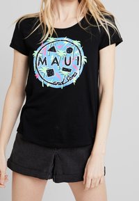 Camiseta negra de manga corta con un estampado gráfico colorido que presenta el texto "MAUI" y palmeras sobre un fondo azul claro.