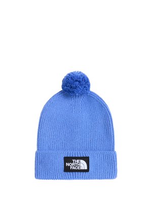 Niebieska dzianinowa czapka z pomponem i podwiniętym mankietem z czarną naszywką z białym logo „The North Face” na środku z przodu.